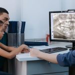 a man and a girl having a dental consultation with a dentist