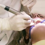 dentist working working on woman s teeth