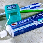 Close-up of dental care items including toothbrush, floss, and toothpaste for oral hygiene.