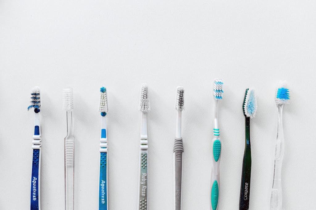 Seven toothbrushes lined up against a white background with copy space above.