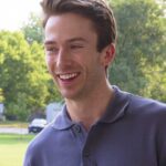 Smiling young man outdoors with teeth visible, suitable for Invisalign or cosmetic dentistry content.